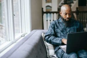 man relaxing while taking an online course