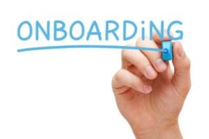 image of hand writing onboarding on a clear board