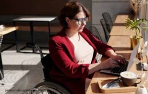 lady in a wheelchair at a cafe doing on demand courses